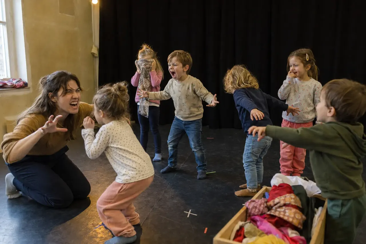 Enfants jouant ensemble dans une salle de théâtre
